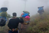 Para porter sedang membawa barang-barang pendaki menuju Gunung Rinjani