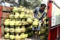 seorang pekerja sedang menurunkan gas LPG 3 kg, subsidi dari atas truk ke pangkalan. dalam beberapa hari terakhir, harga gas LPG di Kabupaten Dompu naik dan mulai susah di cari