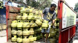 seorang pekerja sedang menurunkan gas LPG 3 kg, subsidi dari atas truk ke pangkalan. dalam beberapa hari terakhir, harga gas LPG di Kabupaten Dompu naik dan mulai susah di cari