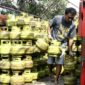 seorang pekerja sedang menurunkan gas LPG 3 kg, subsidi dari atas truk ke pangkalan. dalam beberapa hari terakhir, harga gas LPG di Kabupaten Dompu naik dan mulai susah di cari