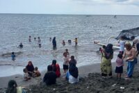 Para wisatawan lokal sedang main air di pantai Gading, Kota Mataram