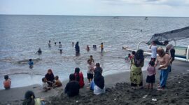 Para wisatawan lokal sedang main air di pantai Gading, Kota Mataram