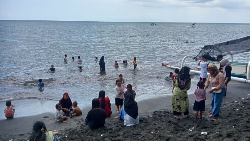 Para wisatawan lokal sedang main air di pantai Gading, Kota Mataram