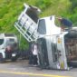 Anggota kepolisian dan TNI bersama warga mengevakuasi truk dam yang terbalik di Jalan Pusuk Sembalun, Kecamatan Sembalun, Lombok Timur, Selasa (16/4/2024). 