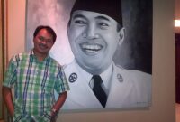 Foto 2013. Penulis dengan lukisan "Bung Karno", koleksi Bapak Fahmi Idris, di Wisma Kodel, Jakarta (foto: ist / ceraken.id) 